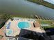 Aerial view of a community pool, hot tub, and lounge area by the water, creating a relaxing oasis at 19451 Gulf Blvd # 205, Indian Shores, FL 33785