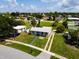 Aerial view of property showcasing the home with well-maintained landscaping, complemented by a clear, sunny day at 21536 Holdern Ave, Port Charlotte, FL 33952