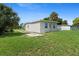 Picture of backyard of the home with a well-maintained lawn and partial view of the property's exterior at 21536 Holdern Ave, Port Charlotte, FL 33952