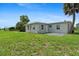 Backyard showcasing the property, featuring a well-maintained lawn and partial exterior home view at 21536 Holdern Ave, Port Charlotte, FL 33952