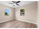 Bedroom with wood floors, neutral walls, ceiling fan and natural light from two windows at 21536 Holdern Ave, Port Charlotte, FL 33952