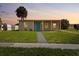 Charming single-story home with a blue front door and a well-manicured lawn at 21536 Holdern Ave, Port Charlotte, FL 33952