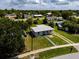 Inviting home featuring a gray exterior, a blue front door, and a spacious lawn at 21536 Holdern Ave, Port Charlotte, FL 33952