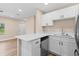 Well-lit modern kitchen with white cabinets, an island, and stainless steel appliances at 21536 Holdern Ave, Port Charlotte, FL 33952