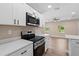 Modern kitchen featuring white cabinets, stainless steel appliances, and sleek countertops at 21536 Holdern Ave, Port Charlotte, FL 33952