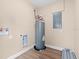 Utility room featuring a hot water heater and electrical panel box, with laminate flooring at 21536 Holdern Ave, Port Charlotte, FL 33952