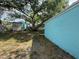 View of the backyard with blue building, shed, and large trees offering ample shade and privacy at 2175 20Th Sw Ave, Largo, FL 33774
