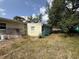 View of overgrown backyard with grass and vegetation, trees, and side of the house at 2175 20Th Sw Ave, Largo, FL 33774