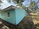 Turquoise exterior of a home showing the corner of the home, yard, and side window at 2175 20Th Sw Ave, Largo, FL 33774