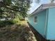Side view of a light blue home exterior with trim and windows, surrounded by greenery at 2175 20Th Sw Ave, Largo, FL 33774