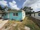 Side view of a light blue home with white trim, landscaping, and a well-kept lawn at 2175 20Th Sw Ave, Largo, FL 33774