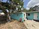 Exterior view of house featuring blue walls and mature tree at 2175 20Th Sw Ave, Largo, FL 33774