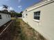 View of side yard with grass and vegetation, fence, and side of the house at 2175 20Th Sw Ave, Largo, FL 33774