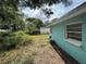 View of the grassy yard with overgrown green shrubs and trees at 2175 20Th Sw Ave, Largo, FL 33774