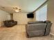 Comfortable living room featuring tile flooring, ceiling fan, and leather recliner sofas at 219 Lovely Ct, Plant City, FL 33566
