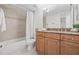 Bathroom featuring a shower-tub combo, vanity with granite counters, and neutral-toned tiles at 2400 Feather Sound Dr # 528, Clearwater, FL 33762