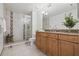 Bathroom featuring a glass shower, double sink vanity with granite counters, and decorative tile accents at 2400 Feather Sound Dr # 528, Clearwater, FL 33762