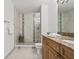 Bathroom featuring a glass shower, double sink vanity with granite counters, and decorative tile accents at 2400 Feather Sound Dr # 528, Clearwater, FL 33762