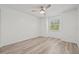Bright bedroom with ceiling fan, laminate floors, and a window overlooking trees at 2400 Feather Sound Dr # 528, Clearwater, FL 33762