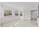 Bright dining area with white walls, tiled floors, and a modern light fixture under three large windows at 2400 Feather Sound Dr # 528, Clearwater, FL 33762