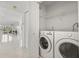 Convenient laundry room with modern, front-loading washer and dryer, as well as built-in shelving at 2400 Feather Sound Dr # 528, Clearwater, FL 33762