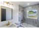 Modern bathroom with elegant gray tiles, gold fixtures, and a shower-tub combination at 2425 Wishing Well Cir, Tampa, FL 33619