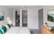 Bedroom with modern decor, including neutral walls, bed with emerald pillows, and ensuite bathroom at 2425 Wishing Well Cir, Tampa, FL 33619