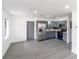 Open floor plan featuring gray cabinets, stainless steel fridge, and sleek gray flooring at 2425 Wishing Well Cir, Tampa, FL 33619