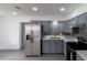 Renovated kitchen with gray cabinets, stainless steel refrigerator and updated backsplash at 2425 Wishing Well Cir, Tampa, FL 33619