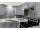 Updated kitchen showcasing modern gray cabinets, stainless steel appliances, and quartz countertops at 2425 Wishing Well Cir, Tampa, FL 33619