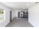 Bright living room with white walls, gray floors, and modern stainless steel appliances in the adjacent kitchen at 2425 Wishing Well Cir, Tampa, FL 33619