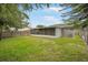 Backyard with a screened lanai, green grass and a wood fence at 24841 Mary Beth Ct, Land O Lakes, FL 34639