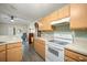 Well-lit kitchen with hardwood cabinets and white appliances at 24841 Mary Beth Ct, Land O Lakes, FL 34639