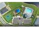An aerial view shows a community pool, playground, basketball court, and parking area near a pond and multiple homes at 2522 Charter Oak Dr, North Port, FL 34289