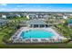 Aerial view of the community pool, complete with umbrellas, lounge chairs, and a covered picnic area inside a fenced perimeter at 2522 Charter Oak Dr, North Port, FL 34289