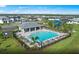 Aerial view of a community pool with plenty of chairs, umbrellas, and a covered gazebo with several houses surrounding the area at 2522 Charter Oak Dr, North Port, FL 34289