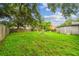 Large backyard with green grass, mature trees, and a fire pit, perfect for outdoor gatherings at 2607 N 59Th St, Tampa, FL 33619