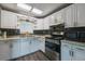 Well-lit kitchen with stainless steel appliances, white cabinets, and a stylish backsplash, perfect for cooking enthusiasts at 2607 N 59Th St, Tampa, FL 33619