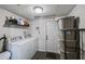 Functional laundry room featuring a washer and dryer, storage shelving, and easy access to the exterior at 2607 N 59Th St, Tampa, FL 33619