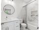 Modern bathroom with a white vanity, round mirror, and tiled shower-tub combination at 2809 N 21St St, Tampa, FL 33605