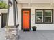 Close-up of the home's bright orange front door, with modern stone accents and stylish black trim at 2809 N 21St St, Tampa, FL 33605