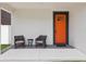 Inviting front porch with seating and a bright orange front door, adding curb appeal to the home at 2809 N 21St St, Tampa, FL 33605