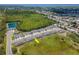 Aerial view captures the community's townhomes, landscaping, and street layout near a scenic pond at 3062 Victoria Inlet Dr, Holiday, FL 34691