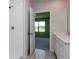 Bathroom shower with white tile, next to a white vanity and large mirror at 3062 Victoria Inlet Dr, Holiday, FL 34691