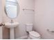 Clean powder room with a pedestal sink, oval mirror, and a standard toilet at 3062 Victoria Inlet Dr, Holiday, FL 34691