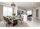 Dining room with large windows, stylish light fixture, and an open view to the kitchen at 3062 Victoria Inlet Dr, Holiday, FL 34691