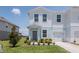 Attractive townhome featuring light blue accents, a one-car garage, and a tidy front lawn at 3062 Victoria Inlet Dr, Holiday, FL 34691