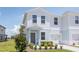 Inviting two-story townhome with a well-kept lawn, garden beds, and a one-car garage at 3062 Victoria Inlet Dr, Holiday, FL 34691
