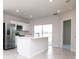 Modern kitchen has stainless steel appliances, sleek white cabinetry, and an island with sink and breakfast bar at 3062 Victoria Inlet Dr, Holiday, FL 34691