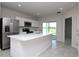 Bright and modern kitchen with stainless steel appliances, white cabinets, and a large island with a sink at 3062 Victoria Inlet Dr, Holiday, FL 34691